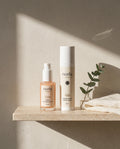 Norla Vera serum and Ada AM/PM cream on a travertine bathroom shelf