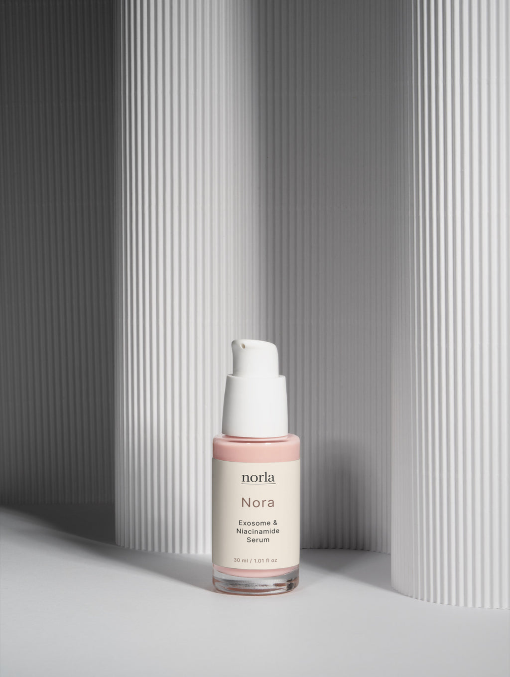 Nora — Exosome & Niacinamide Serum by Norla against a soft fluted backdrop